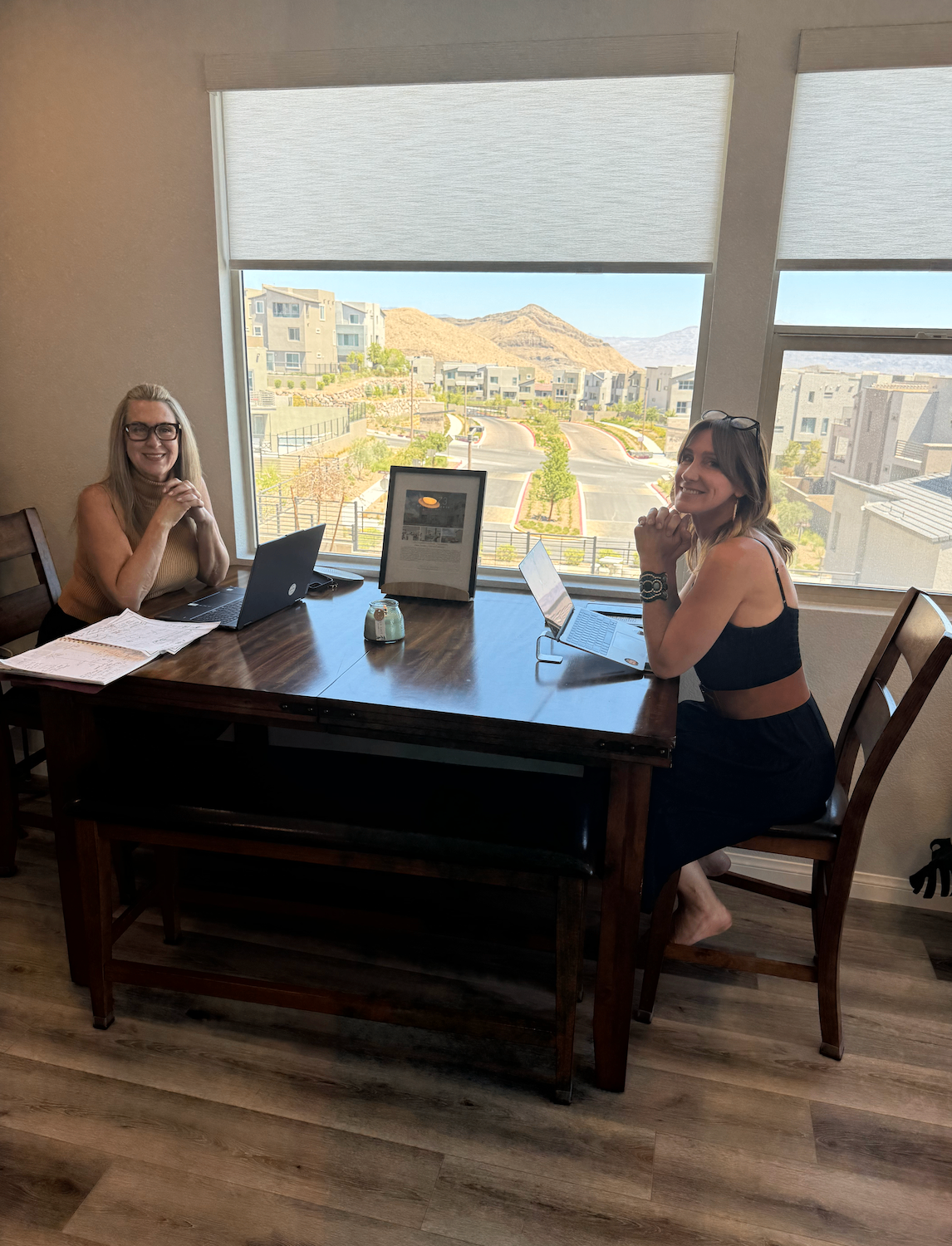 Ashley Bell reviewing paperwork with a client at a dining table overlooking a Summerlin neighborhood