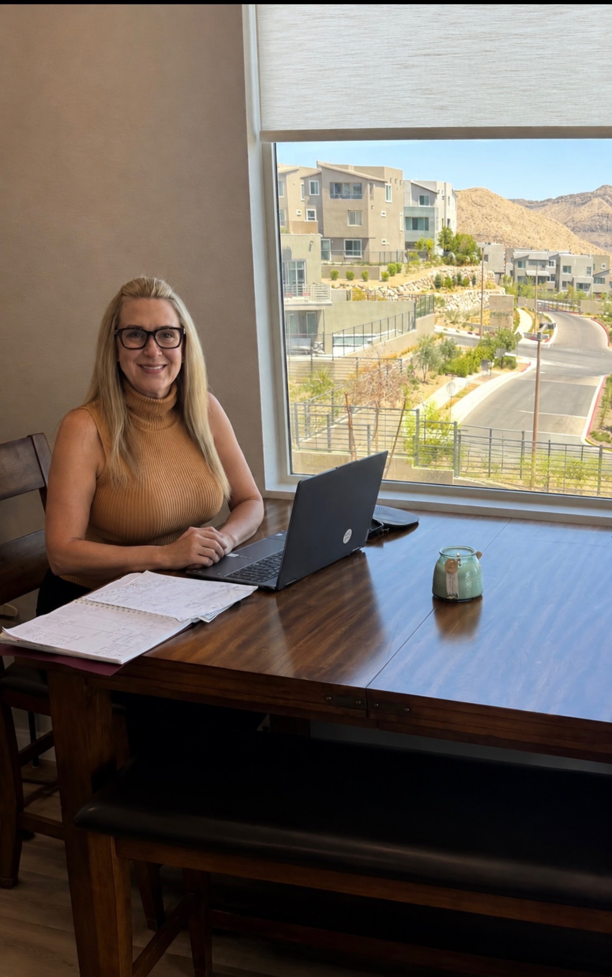 Ashley Bell working on contracts at her desk with a view of the Las Vegas foothills